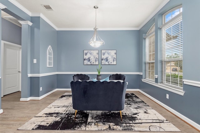 dining area featuring visible vents, baseboards, wood finished floors, and crown molding