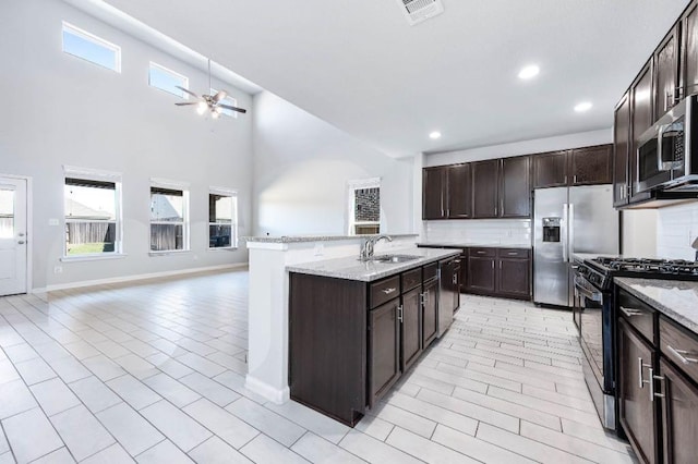 kitchen featuring visible vents, a ceiling fan, a sink, tasteful backsplash, and appliances with stainless steel finishes