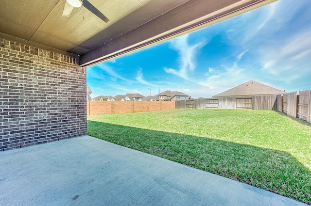 view of yard featuring a fenced backyard, a ceiling fan, and a patio area