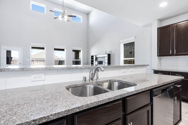 kitchen featuring ceiling fan, decorative backsplash, dark brown cabinetry, a sink, and dishwasher