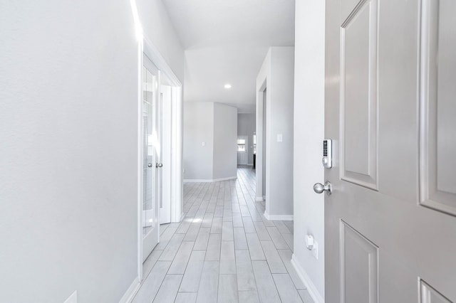 hall with baseboards and wood finish floors