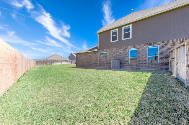 view of yard with central air condition unit and a fenced backyard