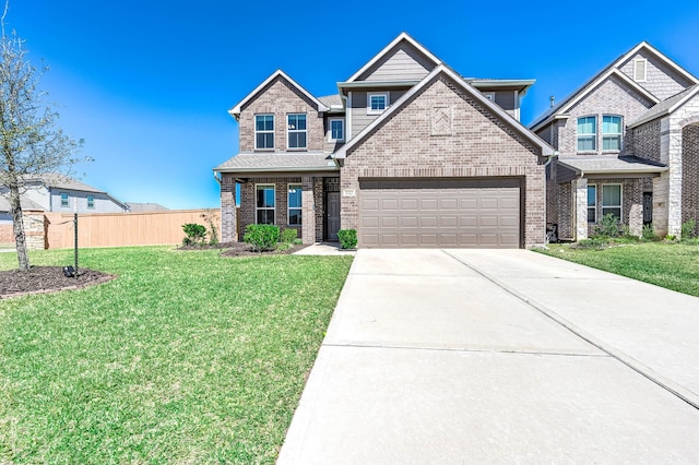 craftsman inspired home featuring brick siding, a front lawn, fence, a garage, and driveway