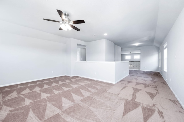 carpeted spare room with baseboards and ceiling fan