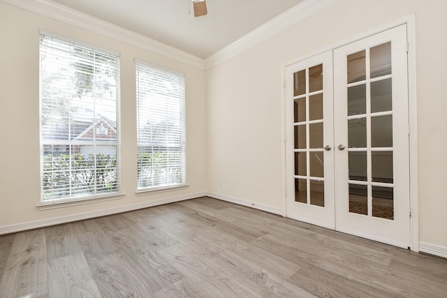 spare room with ornamental molding, a ceiling fan, wood finished floors, french doors, and baseboards