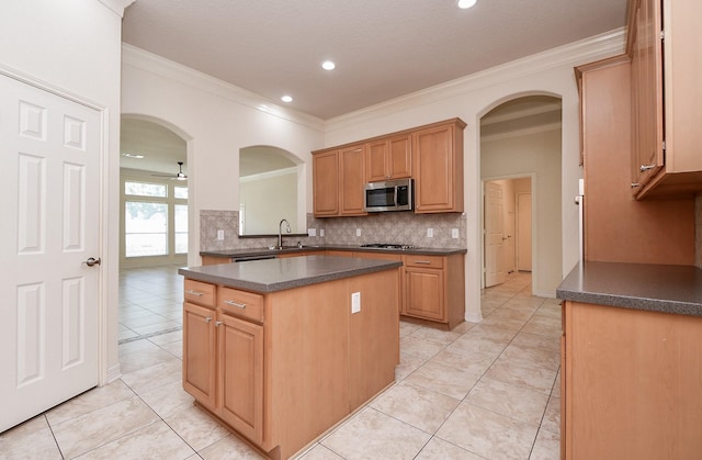 kitchen featuring dark countertops, decorative backsplash, stainless steel appliances, and a sink