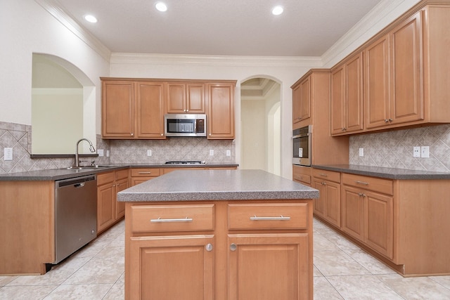 kitchen with a kitchen island, crown molding, arched walkways, stainless steel appliances, and a sink