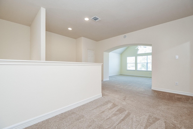 empty room featuring visible vents, baseboards, carpet flooring, recessed lighting, and arched walkways