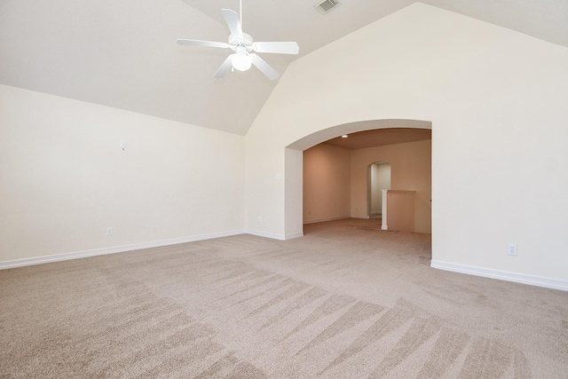 empty room with light colored carpet, a ceiling fan, arched walkways, and high vaulted ceiling