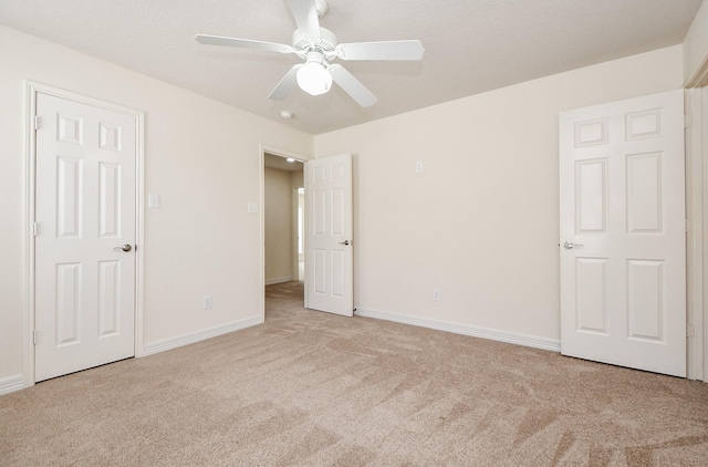 unfurnished bedroom featuring a ceiling fan, baseboards, and carpet floors