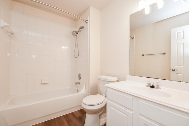 bathroom with shower / bathtub combination, toilet, wood finished floors, and vanity