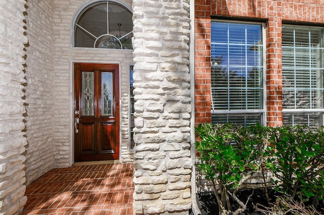 view of exterior entry with brick siding