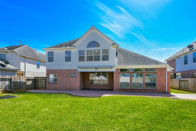 back of property featuring a patio area, a lawn, and brick siding