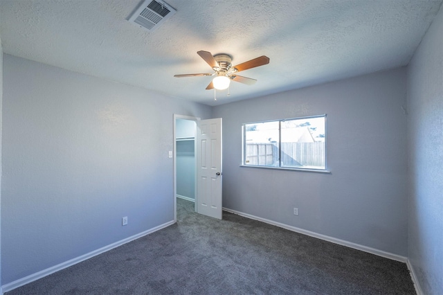 unfurnished bedroom featuring visible vents, a ceiling fan, a textured ceiling, carpet floors, and baseboards