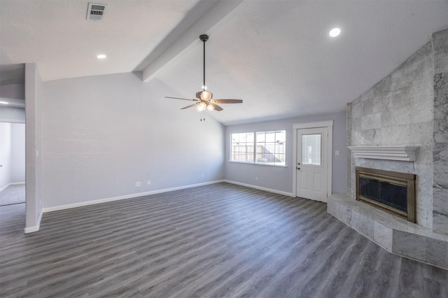 unfurnished living room with visible vents, a ceiling fan, a tiled fireplace, wood finished floors, and vaulted ceiling with beams