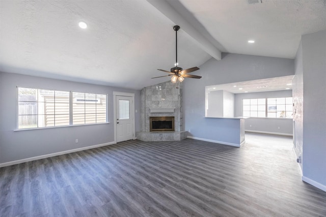 unfurnished living room featuring vaulted ceiling with beams, wood finished floors, baseboards, and ceiling fan