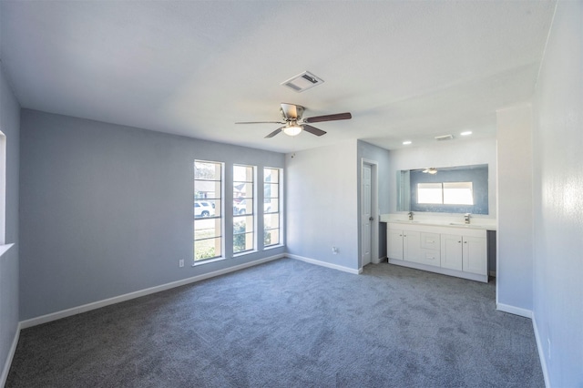 unfurnished bedroom featuring light carpet, visible vents, baseboards, and a sink