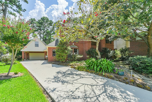 view of property hidden behind natural elements with a front lawn, a garage, brick siding, and driveway