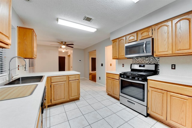 kitchen featuring tasteful backsplash, visible vents, appliances with stainless steel finishes, a peninsula, and a sink