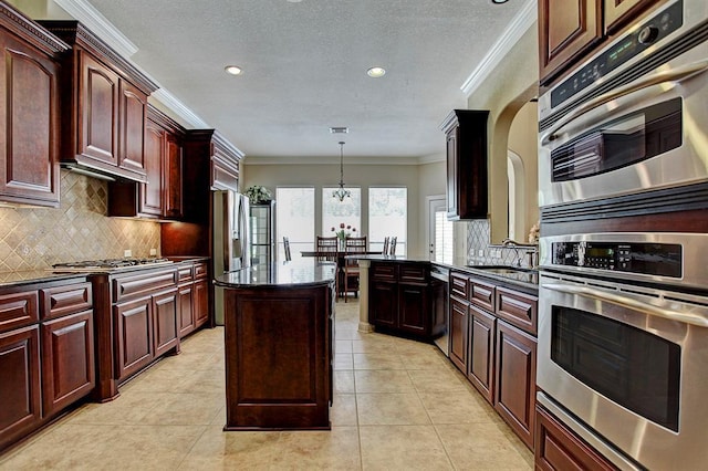 12610 Blanco Terrace Ln, Houston, TX 77041 - kitchen with appliances with stainless steel finishes, crown molding, decorative backsplash, recessed lighting, and a kitchen island
