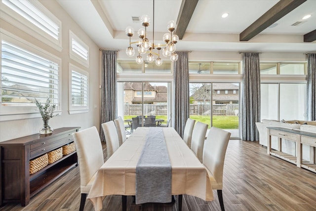 dining space with beamed ceiling, wood finished floors, and a chandelier