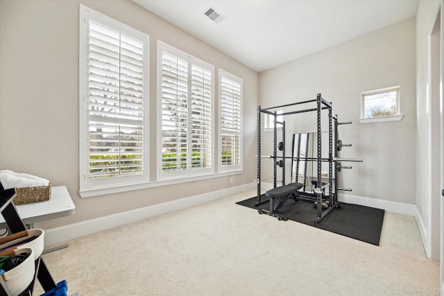 exercise room featuring visible vents, baseboards, and carpet floors