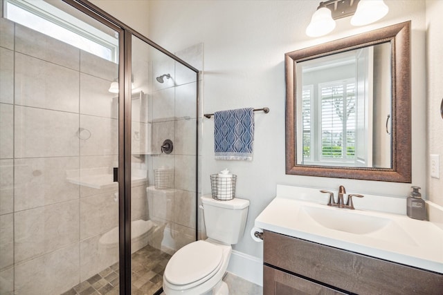 bathroom with toilet, a shower stall, and vanity