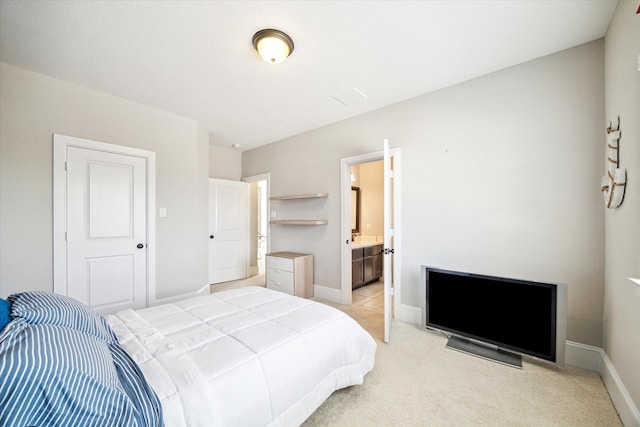 bedroom featuring light colored carpet, ensuite bathroom, and baseboards