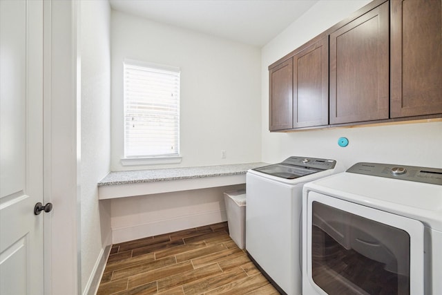 washroom with separate washer and dryer, cabinet space, baseboards, and wood finish floors