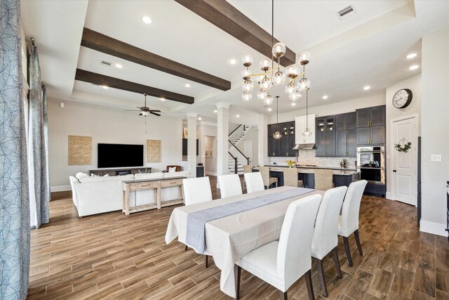 dining space with beam ceiling, visible vents, baseboards, and wood tiled floor