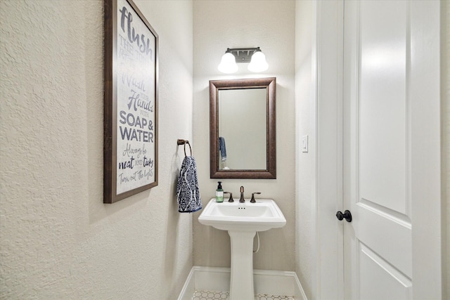 bathroom featuring baseboards and a textured wall