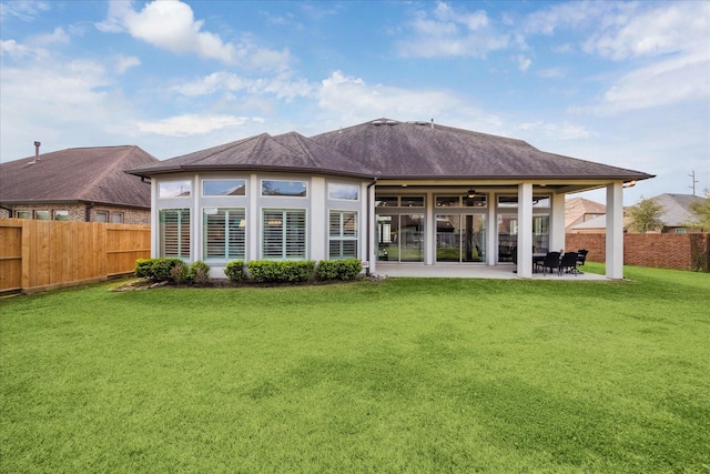 rear view of house with a patio, a yard, a fenced backyard, and ceiling fan