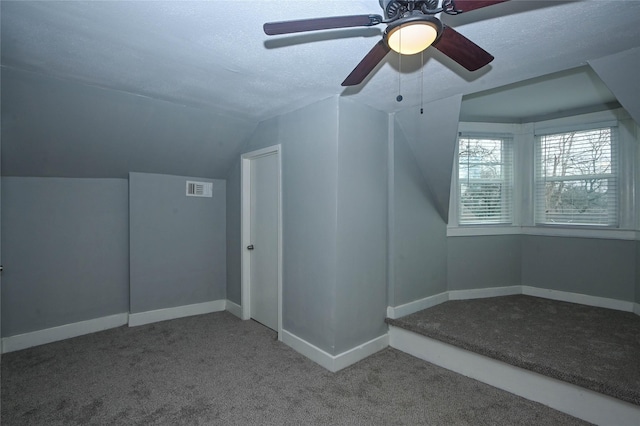 bonus room featuring baseboards, visible vents, carpet floors, vaulted ceiling, and a textured ceiling