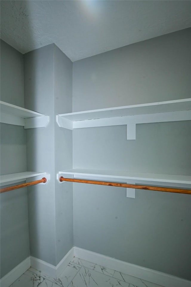 walk in closet with marble finish floor