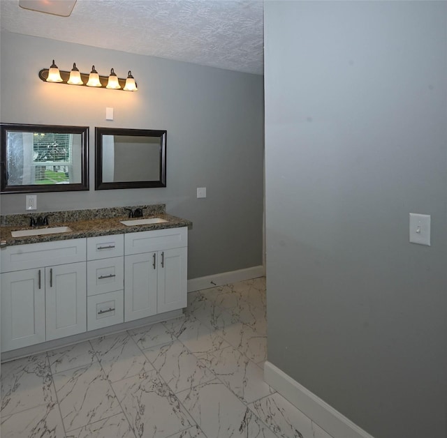 bathroom with a sink and marble finish floor