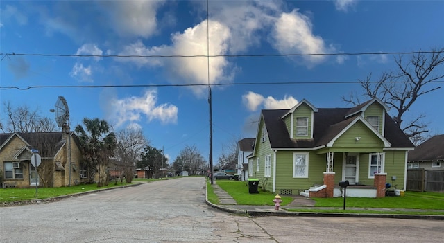 view of front of home with a residential view, a front lawn, and fence