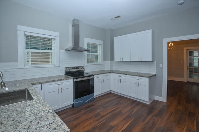 kitchen featuring wall chimney range hood, light stone countertops, dark wood-style floors, electric range, and a sink