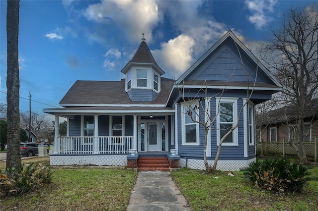 victorian home featuring a porch and a front lawn