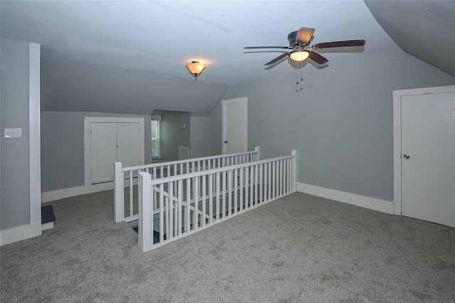 additional living space featuring carpet flooring, baseboards, a ceiling fan, and vaulted ceiling