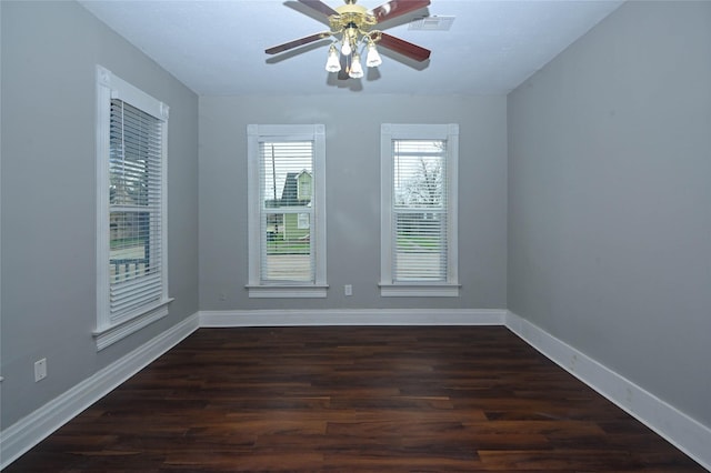 spare room featuring a ceiling fan, visible vents, wood finished floors, and baseboards