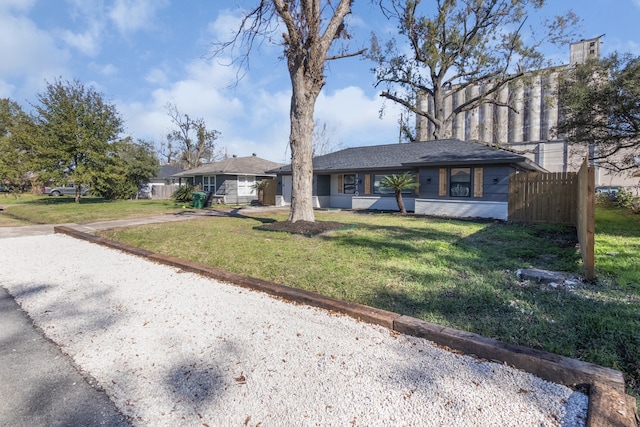 view of front facade with brick siding, a front yard, and fence