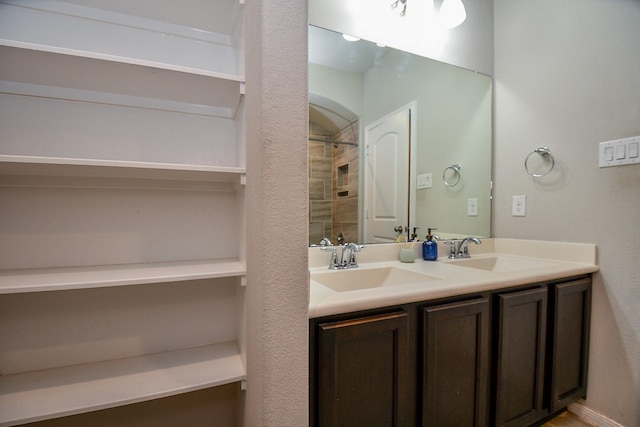 30903 Roanoak Woods Dr, Tomball, TX 77375 - bathroom featuring tiled shower, double vanity, and a sink