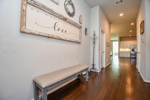 hallway with visible vents, recessed lighting, baseboards, and dark wood-style flooring