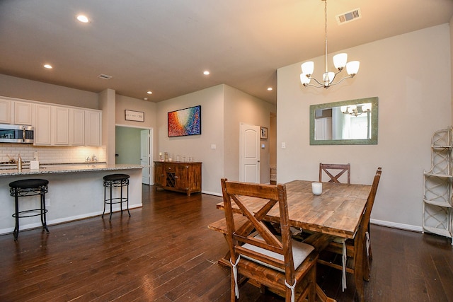 dining space with a chandelier, visible vents, baseboards, and dark wood-style flooring