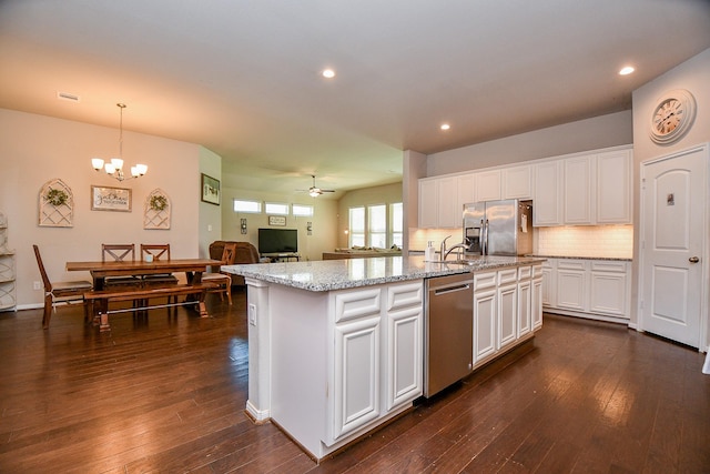 kitchen featuring ceiling fan with notable chandelier, dark wood-style floors, white cabinetry, appliances with stainless steel finishes, and decorative backsplash