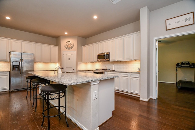 kitchen with dark wood finished floors, white cabinets, and appliances with stainless steel finishes