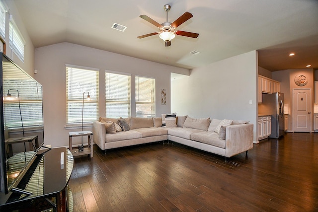 living area featuring dark wood-style floors, visible vents, lofted ceiling, and a ceiling fan