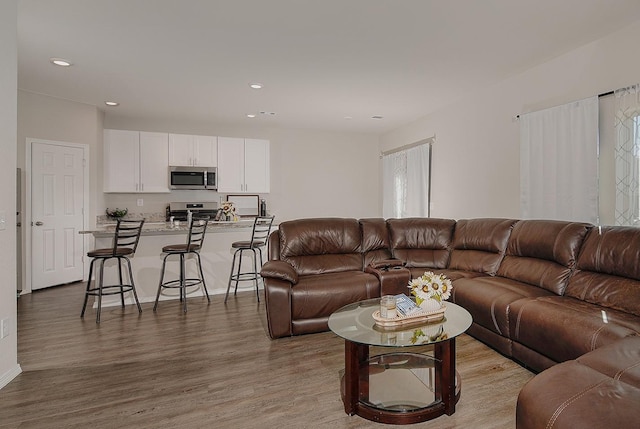 living area with recessed lighting and wood finished floors