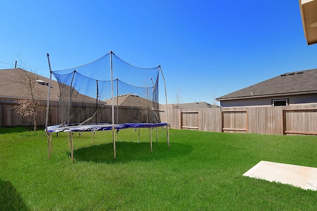 view of yard featuring a fenced backyard and a trampoline