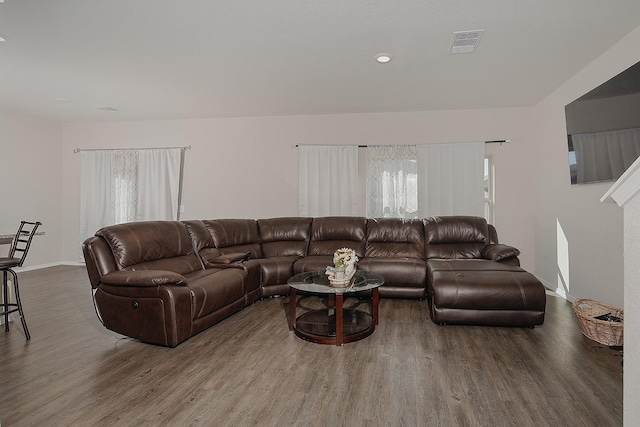 living area featuring wood finished floors, visible vents, and baseboards